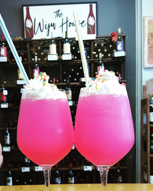 two glasses of Vino Slush Wine Slush Mix slushies with whipped cream